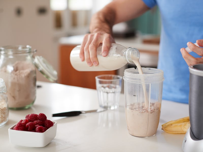 Close Up Of Man Making Protein Shake After Exercise At Home