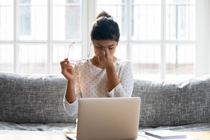 Tired young woman take off glasses massage eyes overwhelmed with computer work have blurry vision, e...