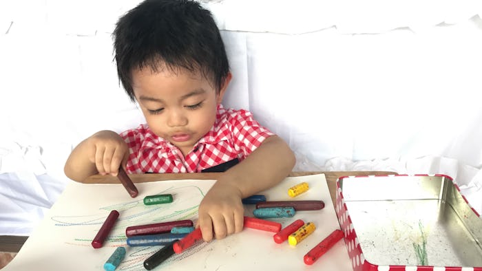 toddler boy playing with crayons