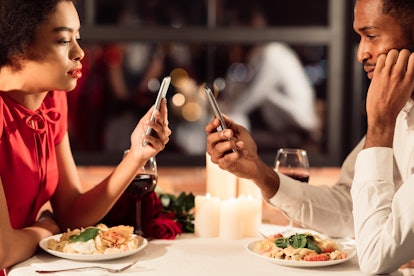 Boring Date. Bored African American Couple Using Mobile Phones During Romantic Dinner Ignoring Each ...