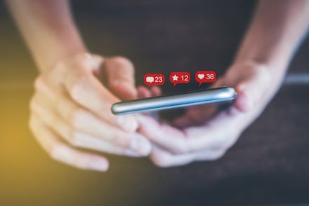 holding mobile phone with notification symbols - girl uses smartphone social media concept