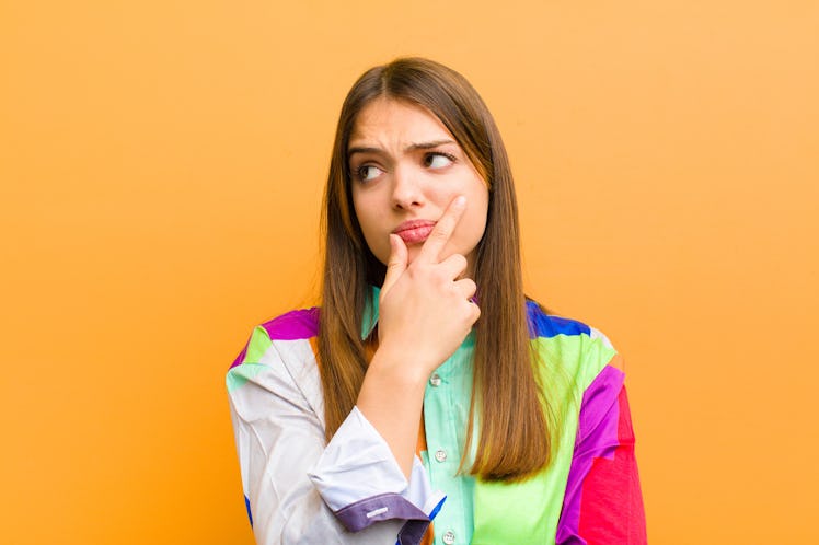 young pretty woman thinking, feeling doubtful and confused, with different options, wondering which ...