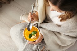 Woman eating tasty cream soup at home