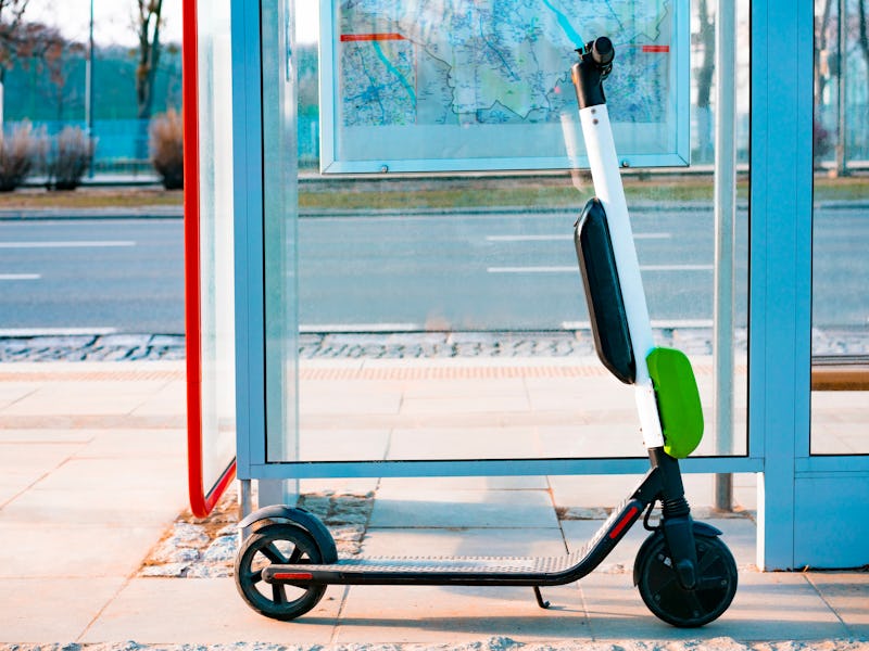 Electric scooter stands near public bus stop. Electric scooters stand along the streets of downtown....