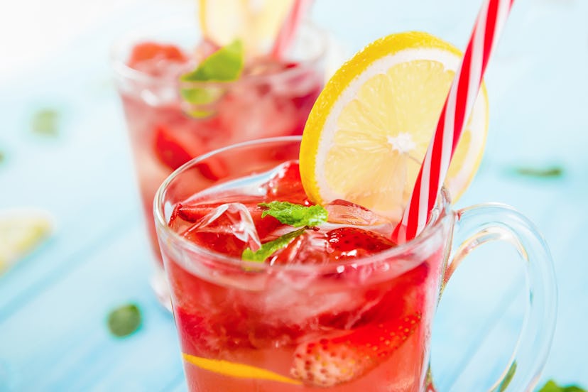 Colorful refreshing drinks for summer, cold strawberry lemonade juice with ice cubes in the glasses ...
