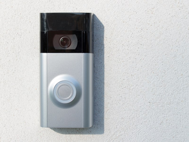 Ring Intercom outdoors  on white plastered wall with call and camera, copy space. 
