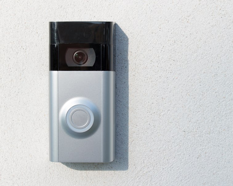Ring Intercom outdoors  on white plastered wall with call and camera, copy space.