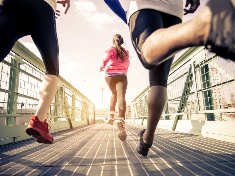 Three runners sprinting outdoors - Sportive people training in a urban area, healthy lifestyle and s...
