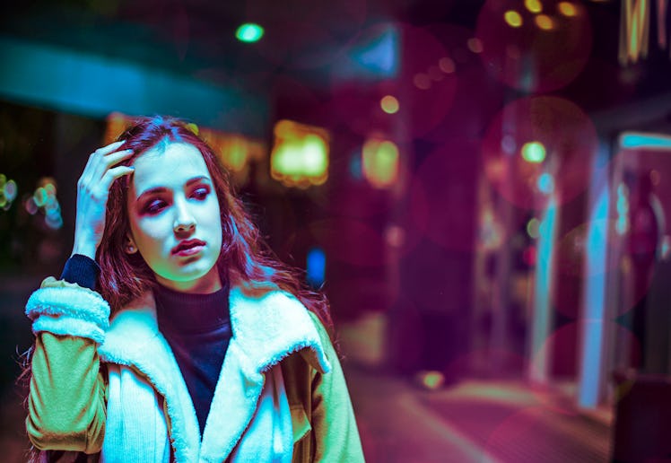 Night in the city, beautiful woman among red and blue neon lights. Sexy young beauty woman posing ov...
