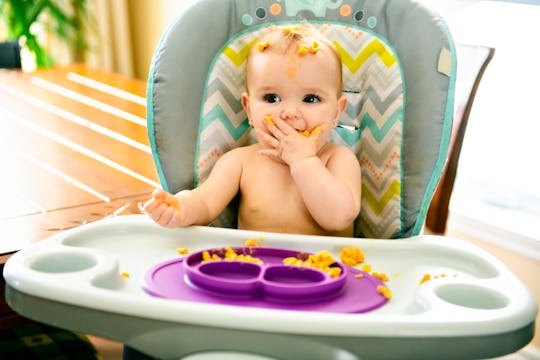 Little baby eating her dinner and making a mess