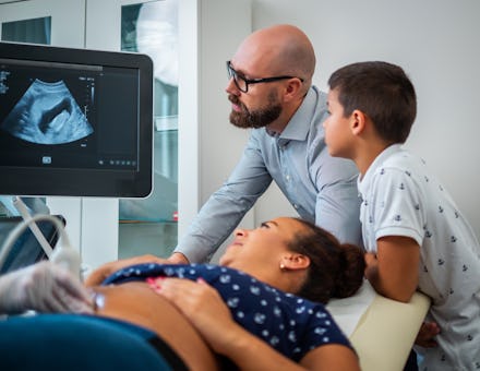 Pregnant woman and her family on utltrasonographic examination at hospital