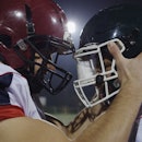 American Football Players having fun and knocking each other with helmet