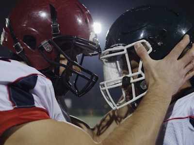 American Football Players having fun and knocking each other with helmet