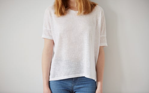 Young girl wearing blank t-shirt and blue jeans. Wall background