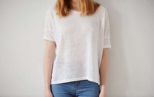Young girl wearing blank t-shirt and blue jeans. Wall background