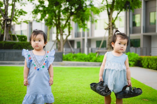 twins girl toddlers playing outside