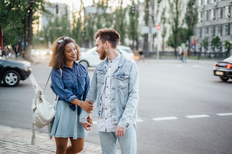 Young couple in love embrace in the street of the european city.