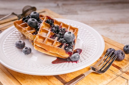 Close-up waffles with blueberries and jam. Sweet dessert. Homemade baking.