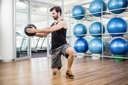 Man doing exercise with medicine ball in the studio