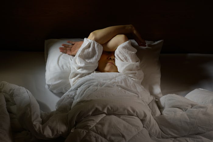 Woman with insomnia lying in bed with open eyes