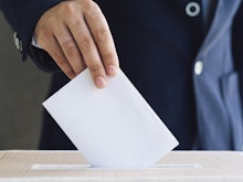 Front view man putting an empty ballot in election box