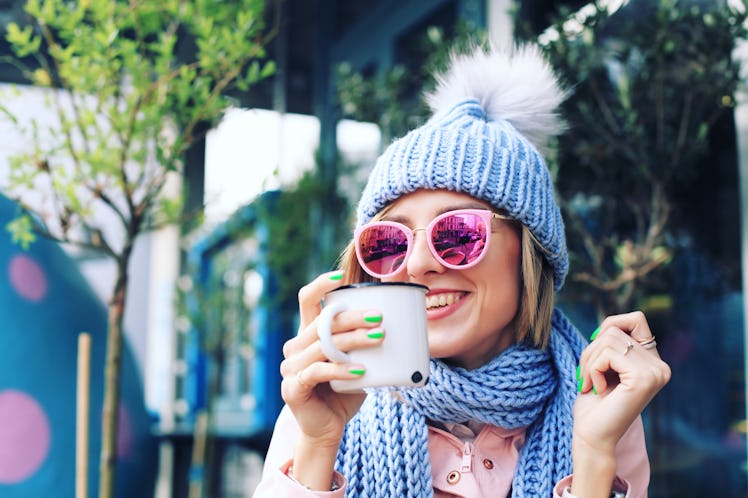 Girl in Winter Clothes in the City Street. Woman in Knitted Sweater, Sunglasses, Beanie and Scarf in...
