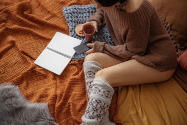 Top view of woman with hot drink and mobile phone stock photo