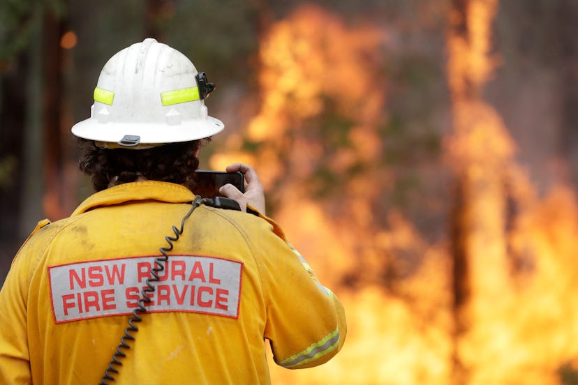 A firefighter uses his phone to record a controlled burn near Tomerong, Australia, in an effort to c...