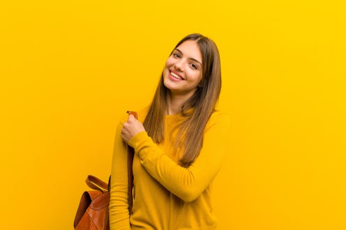young pretty woman feeling happy, positive and successful, motivated when facing a challenge or cele...