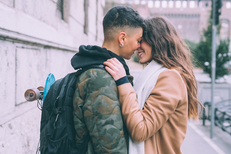 Two  young women lesbian couple outdoor kissing - love, relationship, happiness concept 