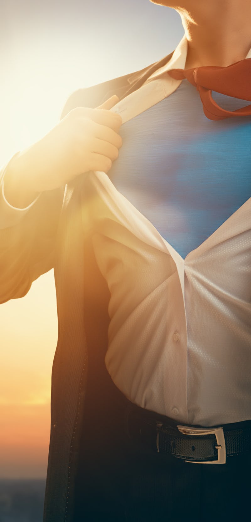 superhero businessman looking at city skyline at sunset. the concept of success, leadership and vict...