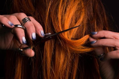 Ginger female haidresser cutting her own hair
