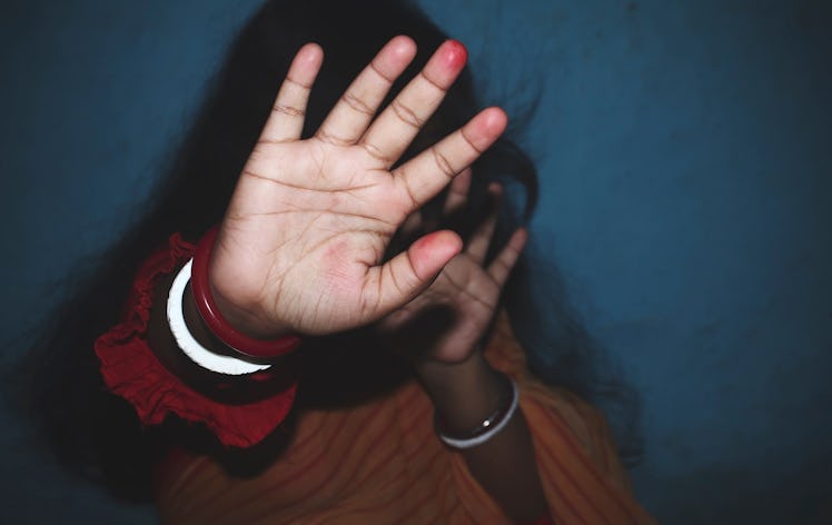Indian housewife showing her hand for protecting herself from his husband.