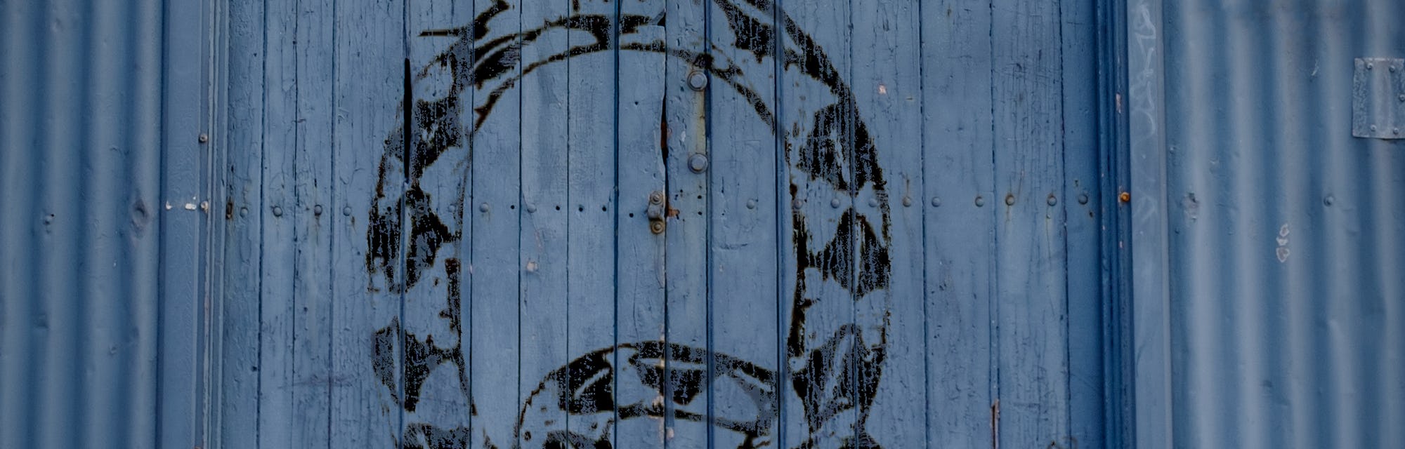 Snake graffiti on old warehouse door which shows the conspiracy theory secret society QAnon's signat...