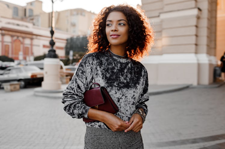 Fashionable black girl in amazing grey velvet sweater , luxury jewelry accessories walking in P...