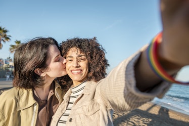 selfie photo of young multiracial couple of beautiful lovely girls smiling and kissing, concept of f...