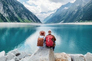 Travelers couple look at the mountain lake. Travel and active life concept with team. Adventure and ...