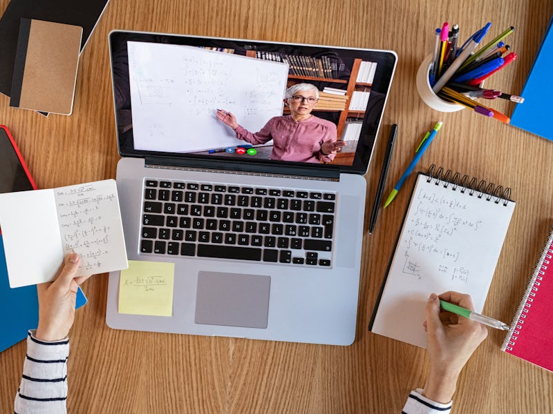 High angle view of video conference with teacher on laptop at home. Top view of girl in video call w...