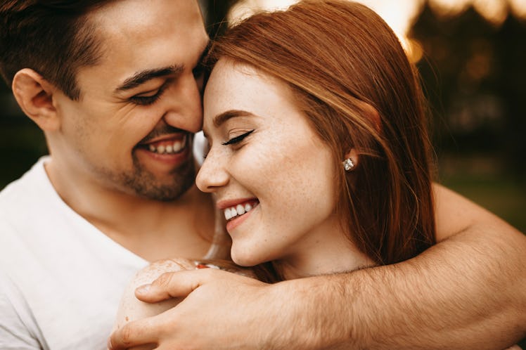 Close up portrait of a amazing young female with red hair and freckles smiling with closed eyes whil...