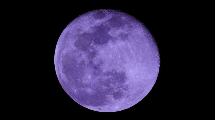 Extreme zoom photo of purple full moon as seen in deep darkness