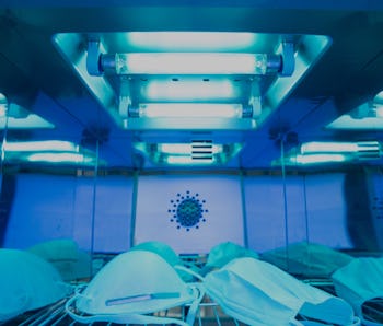 UV light sterilization of face mask to disinfect and reuse. COVID-19 prevention concept. Close up at...