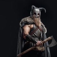 Warrior Viking in full arms with axe and shield on dark background