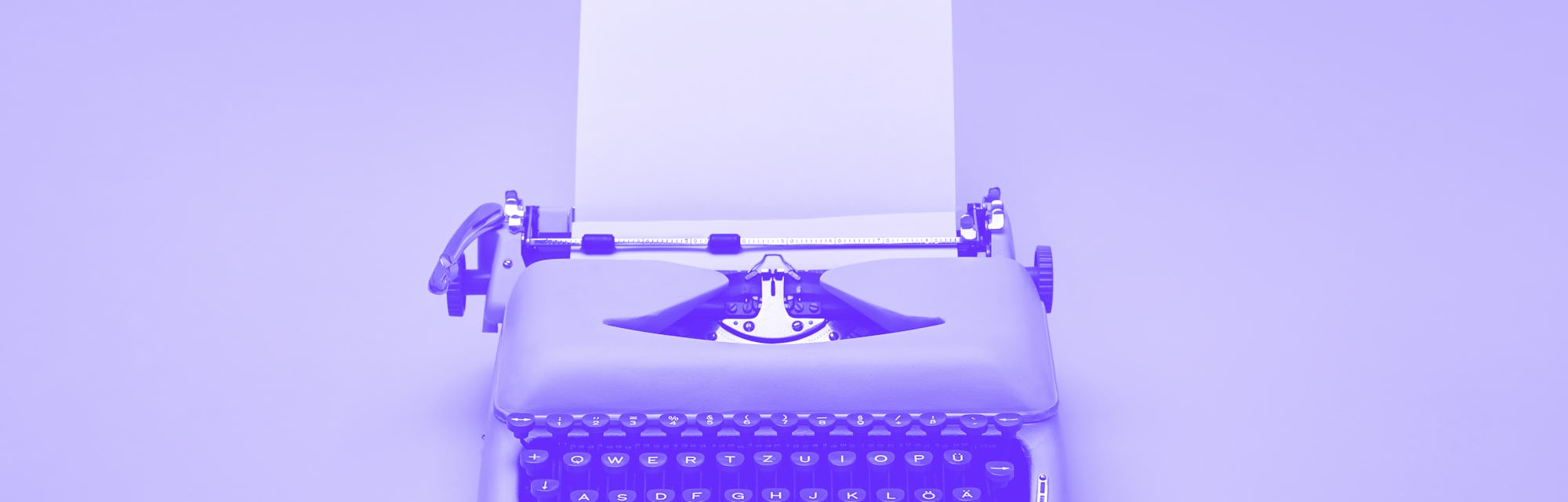 Chic retro typewriter with a paper sheet on the yellow background in the studio.