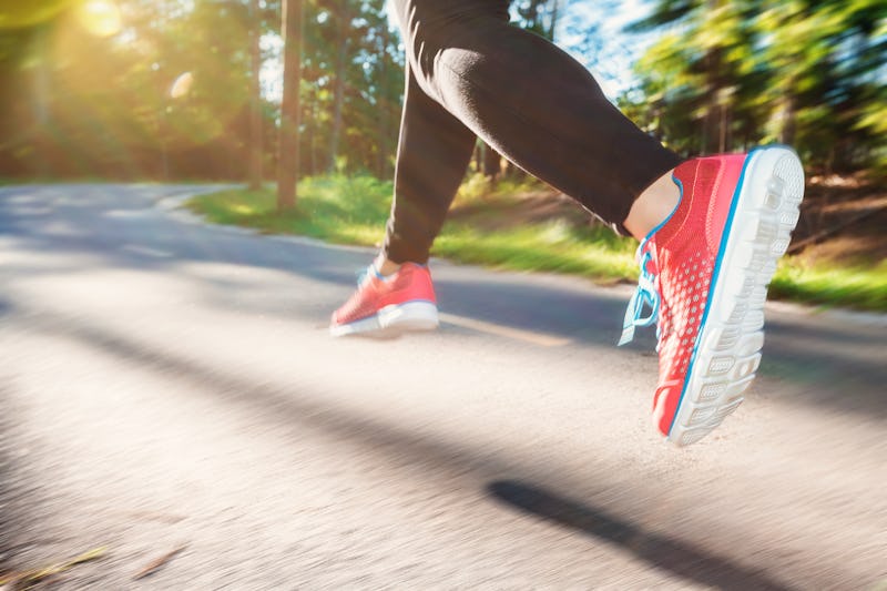 Woman jogging down an outdoor trail at sunset