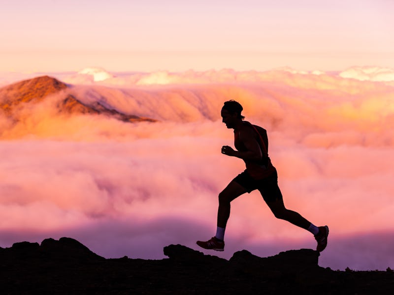 Trail runner athlete man running in nature landscape. Silhouette of male person training on mountain...