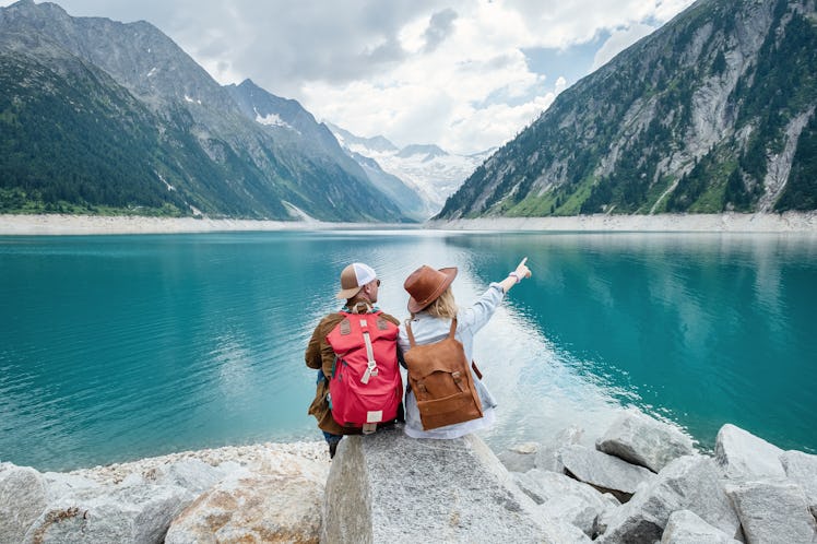 Travelers couple look at the mountain lake. Travel and active life concept with team. Adventure and ...