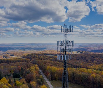 Aerial view of mobiel phone cell tower over forested rural area of West Virginia to illustrate lack ...