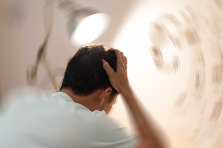 Vertigo illness concept. Man hands on his head felling headache dizzy sense of spinning dizziness,a ...