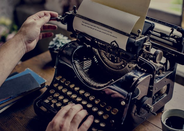 Hands typing on classic vintage typewriter