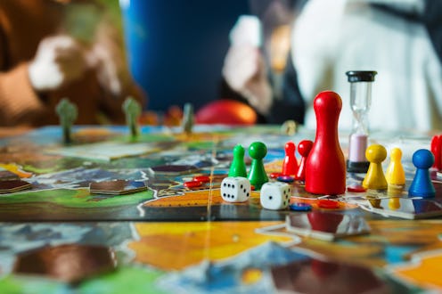 Board game concept- board game field, many figures, meeple, dice, coins and sandglass. Two people pl...